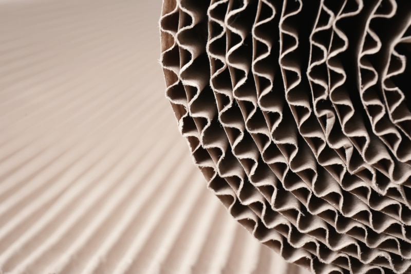 Closeup view of roll of brown corrugated cardboard, space for text. Recyclable material